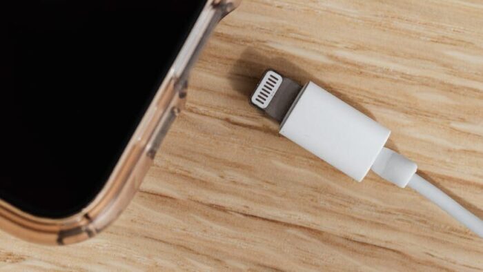 smartphone and charger usb connector on wooden table