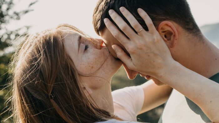 woman kissing boyfriend on forehead