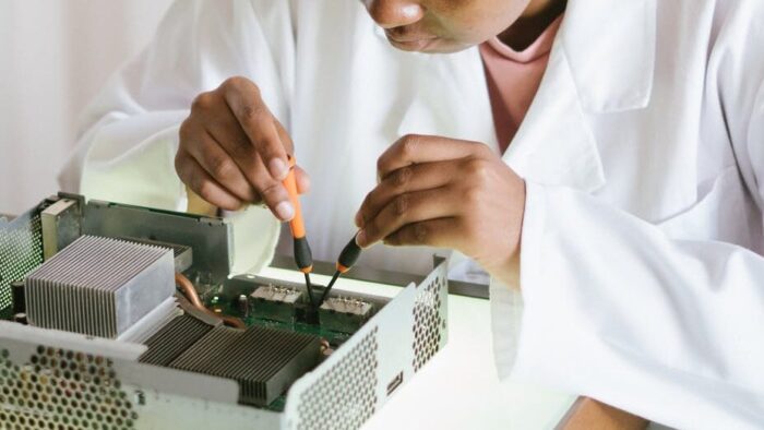 focused african american technical worker replacing faulty elements on video card